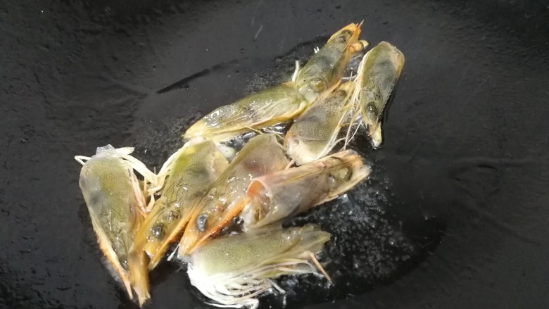 西芹炒虾仁,热锅凉油,油微热放入虾头。