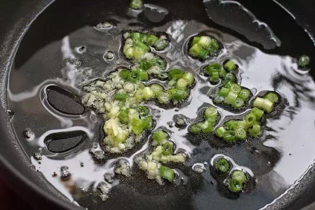 洋葱炒肉片,锅中倒适量食用油烧至五成热,放入葱花和蒜末用小火炒出香味。