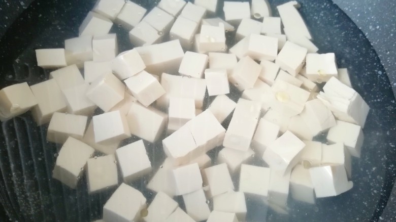 肉末炖豆腐,锅内加水烧开,放一点点盐和几滴食用油,下入豆腐块焯水,捞出控一下水分备用。