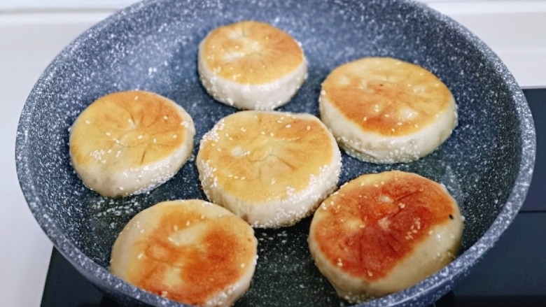 梅干菜烧饼,起锅,加入<a style='color:red;display:inline-block;' href='/shicai/ 849'>花生油</a>,放入饼胚,盖上盖子小火慢煎。(全程小火)底部金黄后翻面,再次盖上盖子,约3分钟。