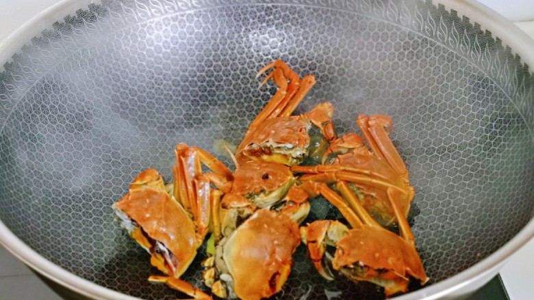 蒜泥螃蟹,加入<a style='color:red;display:inline-block;' href='/shicai/ 718'>料酒</a>翻炒,去腥。