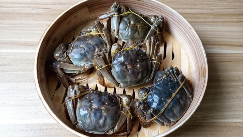清蒸螃蟹,用橡皮筋或者绳子把毛蟹捆一下,防止在蒸熟时影响美观。