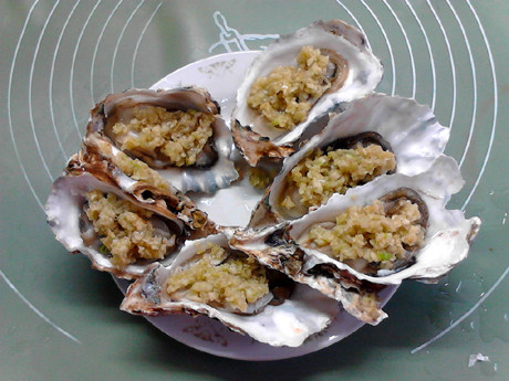 蒜蓉生蚝,把生蚝摆入盘中,将炒过的蒜末放在蚝肉上。