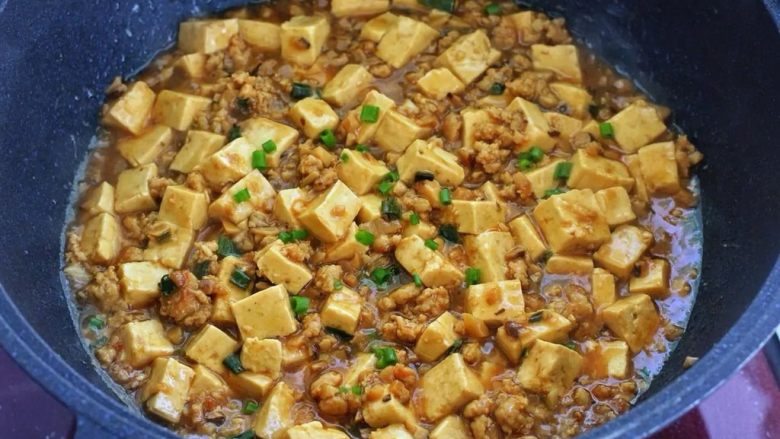 肉末炖豆腐,最后画圈倒入水淀粉翻拌均匀,待汤汁黏稠撒少许葱花点缀,关火盛出即可。