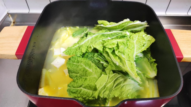 白菜豆腐汤,加入白菜叶,盖上锅盖再煮5分钟。