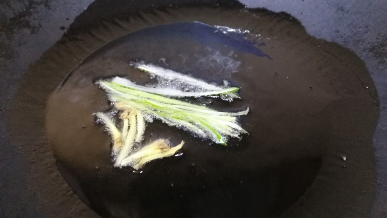 西芹炒牛肉,热锅凉油,放入葱姜丝,文火炒香。