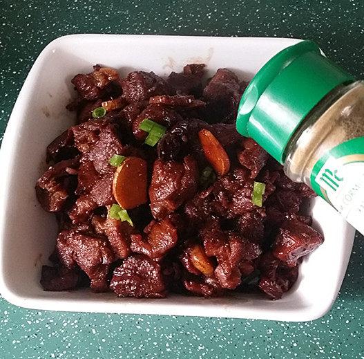 红烧羊肉,出锅装盘,撒上葱花和孜然粉