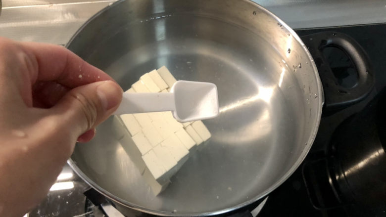 白菜豆腐汤,汤锅坐锅烧水,放入嫩豆腐块,少许食盐,煮开后再煮一分钟