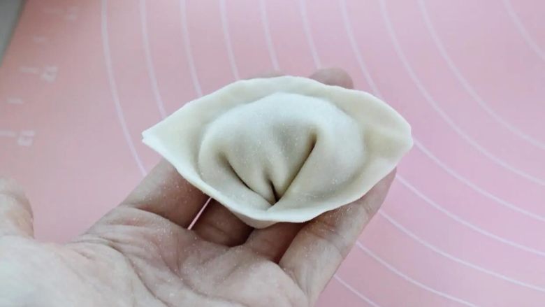 酸辣馄饨,下面的两个角向中间交叠捏紧即可,这是元宝馄饨包法,也可以按照个人的习惯手法来包。
