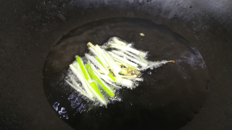 酸菜肉丝面,热锅凉油,油微热放入葱姜丝,小火炒香。(酸菜喜油,比平时炒菜多一些油)