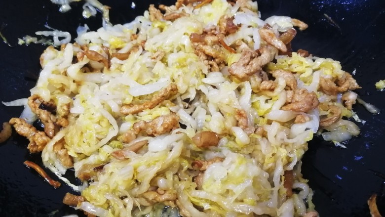 酸菜肉丝面,放入酸菜丝,文火翻炒。