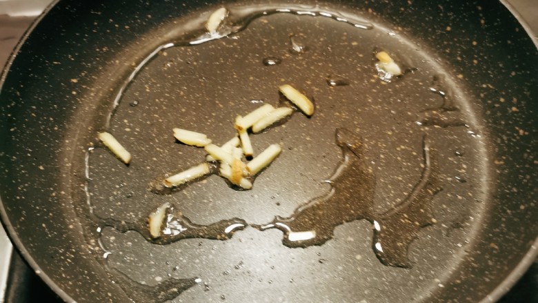 西芹炒虾仁,起油锅,倒入食用油,油热后放入姜丝爆香。