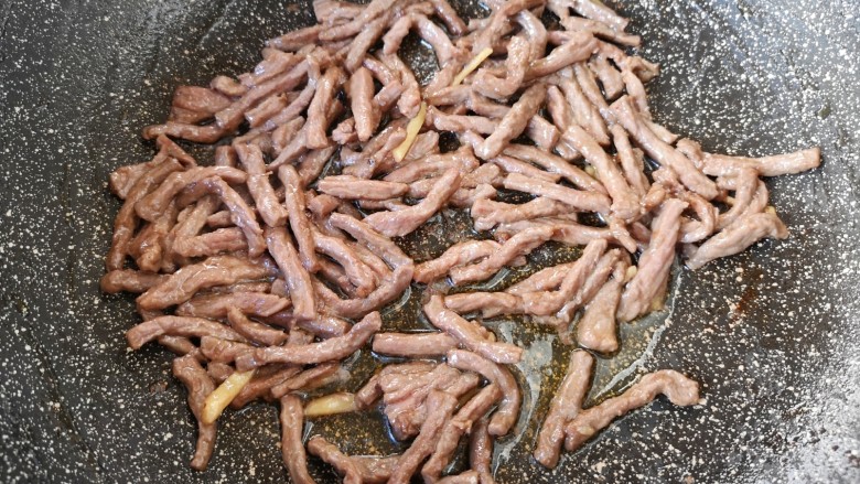 西芹炒牛肉,炒锅内倒适量的食用油烧热,下入腌制好的牛肉丝炒熟,盛出备用。