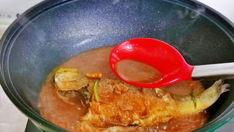 红烧鱼,这时汤汁浓郁,大火收汤,用勺子盛汤汁往鱼身上淋,反复多次,直到汤汁浓稠。