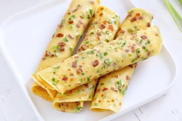 培根鸡蛋饼,重复以上步骤将所有的面糊烙成鸡蛋饼,简单又美味的营养早餐就做好了。