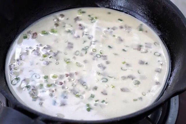 培根鸡蛋饼,在平底锅中涂抹少量的食用油,舀一勺面糊倒进去,晃动锅使面糊均匀的摊开。