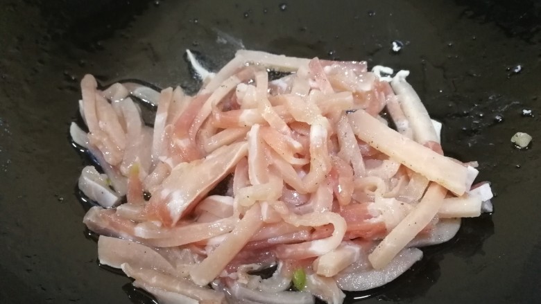 青椒炒肉丝,热锅凉油,不等油热放入肉丝翻炒。