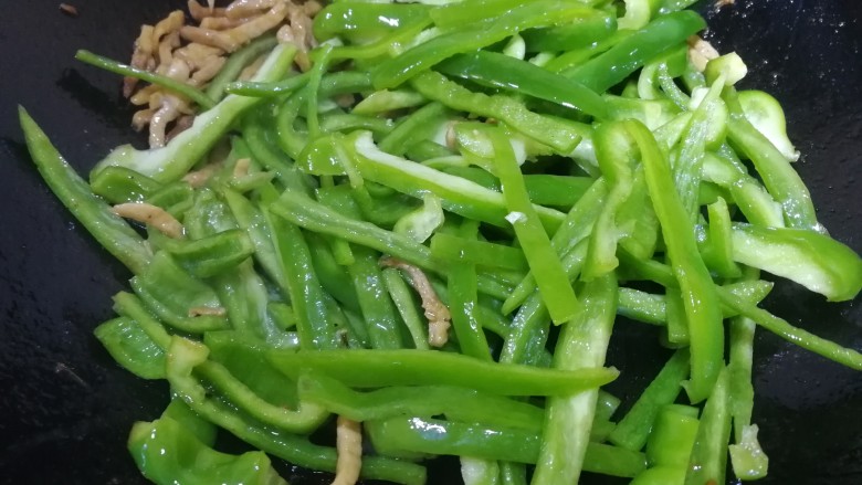 青椒炒肉丝,文火翻炒均匀,热锅包裹上青椒。