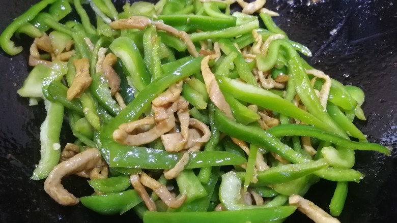青椒炒肉丝,再和肉丝文火翻炒均匀,这时青椒被炒的噼啪响,香味飘出来。