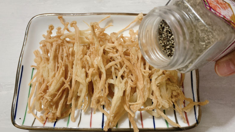 孜然金针菇,出锅控油后,撒上黑椒盐和孜然粉