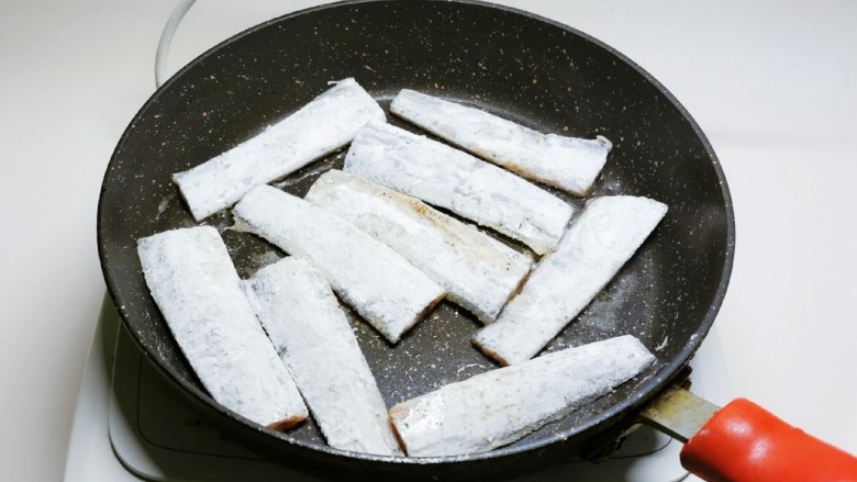 炸鱼块,起油锅放入食用油,放入包裹了面粉的鱼段。