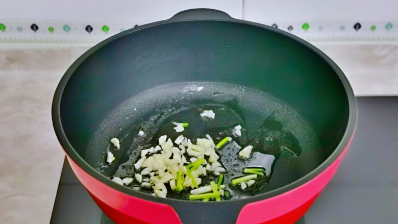 白菜炒肉片,起油锅,加入葱白与蒜末煸炒出香味。