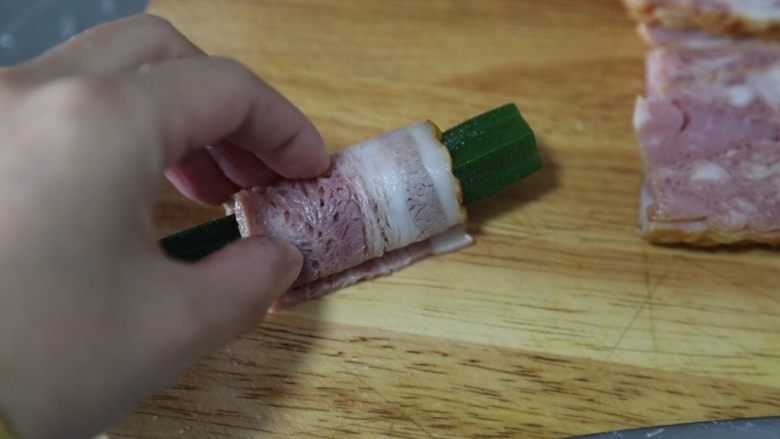 培根秋葵卷,取一片,将秋葵裹起来
