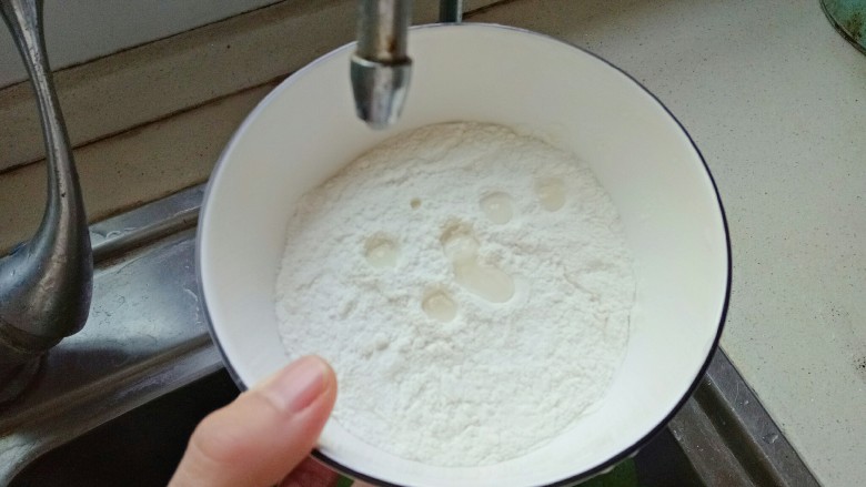 西红柿面疙瘩,水龙头开关开最小,成一滴一滴水流,碗中放入<a style='color:red;display:inline-block;' href='/shicai/ 519'>面粉</a>,放在水龙头下,用筷子不停的搅拌