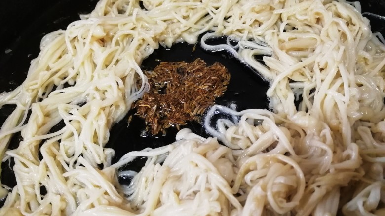 孜然金针菇,锅中心加适量食用油,放入孜然粒,中小火炸出孜然香味。