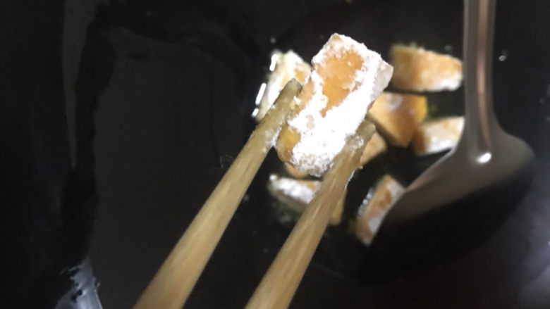 蛋黄南瓜,热锅热油,用筷子夹南瓜放过锅中炸