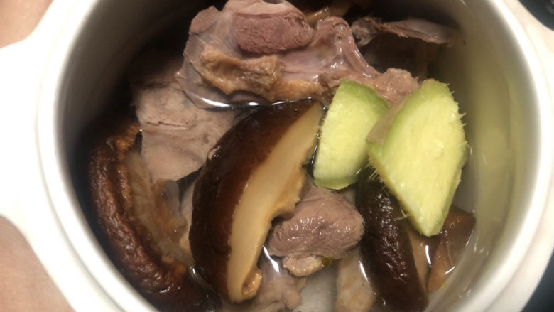 花胶鸽子金汤,炖盅里放入鸽肉,香菇和姜片,倒入矿泉水,喜欢喝汤的可以多倒点水。