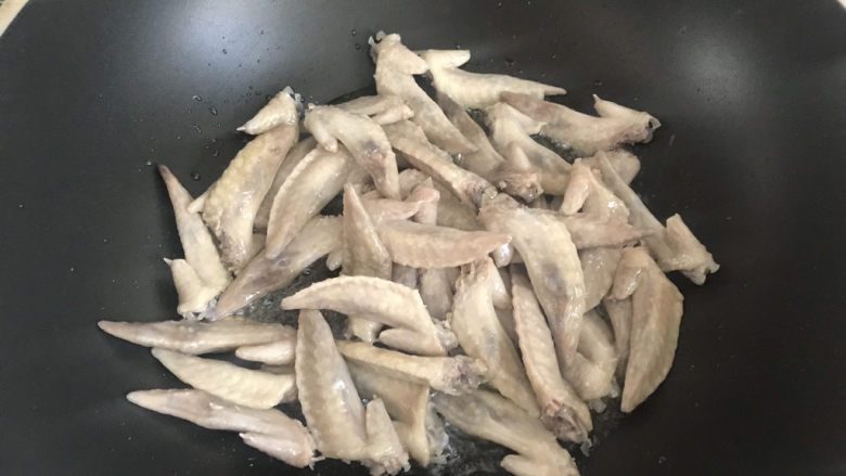 红烧鸡翅尖,起锅热油,下入鸡翅小火煎至表面焦黄