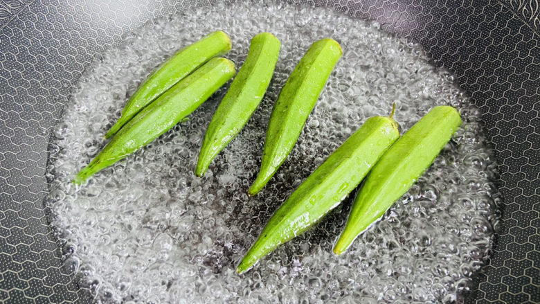 培根秋葵卷,锅中加入清水大火烧开加入适量盐和食用油,放入清洗干净的秋葵。焯熟捞出过凉水
