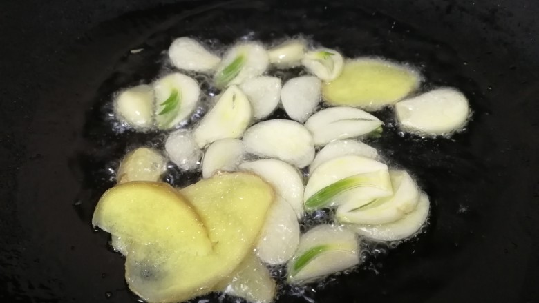 酱爆牛蛙,热锅凉油,油微热放蒜姜片,文火炒香。