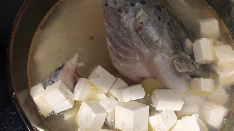 豆腐鱼头汤,煎好之后的鱼头和豆腐一起放入炖锅,加水没过食材的80%即可。因为炖一会儿,食材会缩水,即可没入汤中。撒点<a style='color:red;display:inline-block;' href='/shicai/ 720'>胡椒粉</a>,放几粒<a style='color:red;display:inline-block;' href='/shicai/ 700'>花椒</a>,再倒入适量<a style='color:red;display:inline-block;' href='/shicai/ 718'>料酒</a>,大火烧开后转小火,慢炖四十分钟。