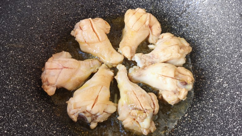 可乐鸡翅根,炒锅内倒入食用油烧热,放入鸡翅根。