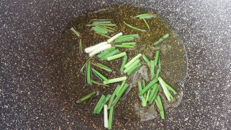 黄瓜炒虾仁,锅底留余油,下入葱段炒香。