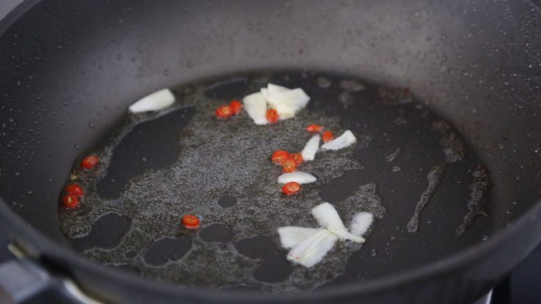 白菜炒肉片,锅里再加入少许油,烧热后爆香蒜片和小米辣