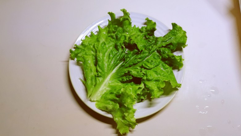 孜然金针菇,取一盘子,铺上生菜叶子。