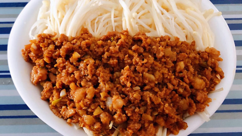 蚝油金针菇,炒好的猪肉馅均匀的摆在金针菇上面