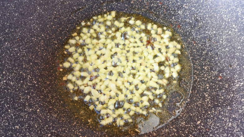 蚝油金针菇,炒锅内倒适量的食用油烧热,下入蒜末炒至金黄色。