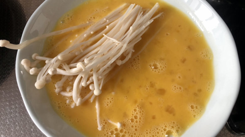 孜然金针菇,开始下锅:一小把金针菇蘸蛋液