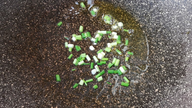 西红柿鸡蛋拌面,锅里继续倒油烧热,下入小葱葱白炒香。