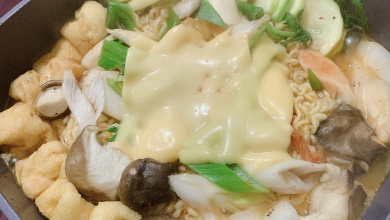 部队火锅,火锅不断沸腾煮至食材成熟,面上再加一片芝士片~如果家里有会拉丝的马苏里拉芝士那就更好了~还可以酌情加一颗鸡蛋~