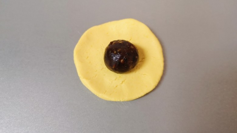 南瓜糯米饼, 取一个搓好的南瓜糯米球压扁,放上枣泥果仁馅。