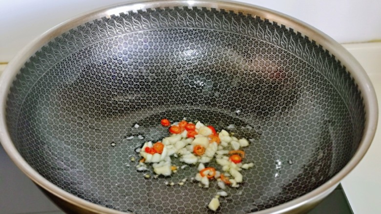 爆炒绿豆芽,起油锅,加入辣椒蒜末煸炒。