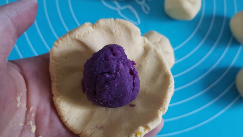 南瓜糯米饼,取一下南瓜面团压成圆饼状,包入紫薯馅