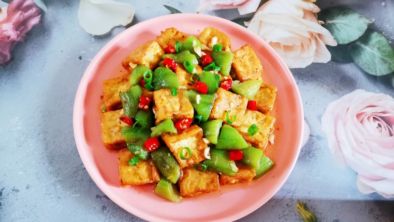 丝瓜炖豆腐,盛入盘中,撒上葱花和红椒点缀,完成!