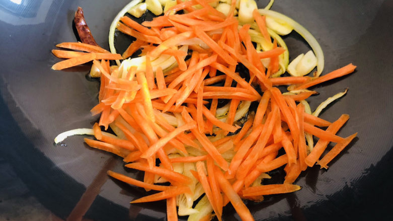 爆炒绿豆芽,放入胡萝卜丝翻炒几下,豆芽比胡萝卜容易熟所以先放胡萝卜丝。
