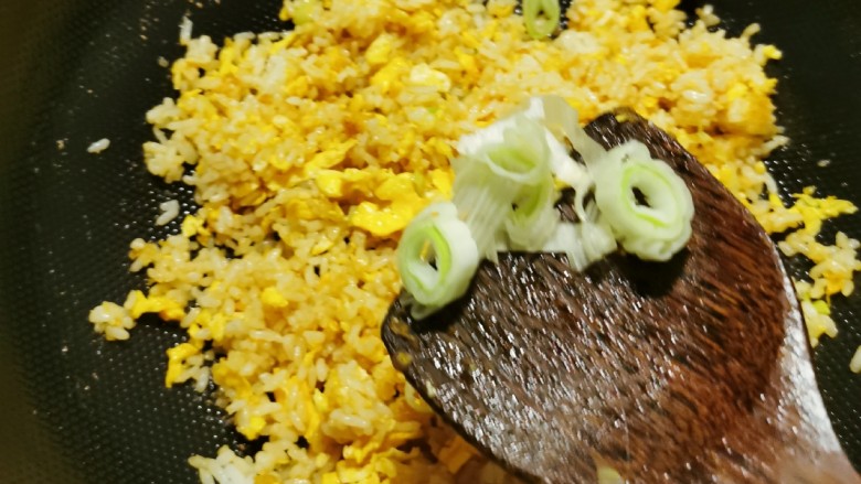 咖喱蛋炒饭,放入剩下的葱花,翻炒。